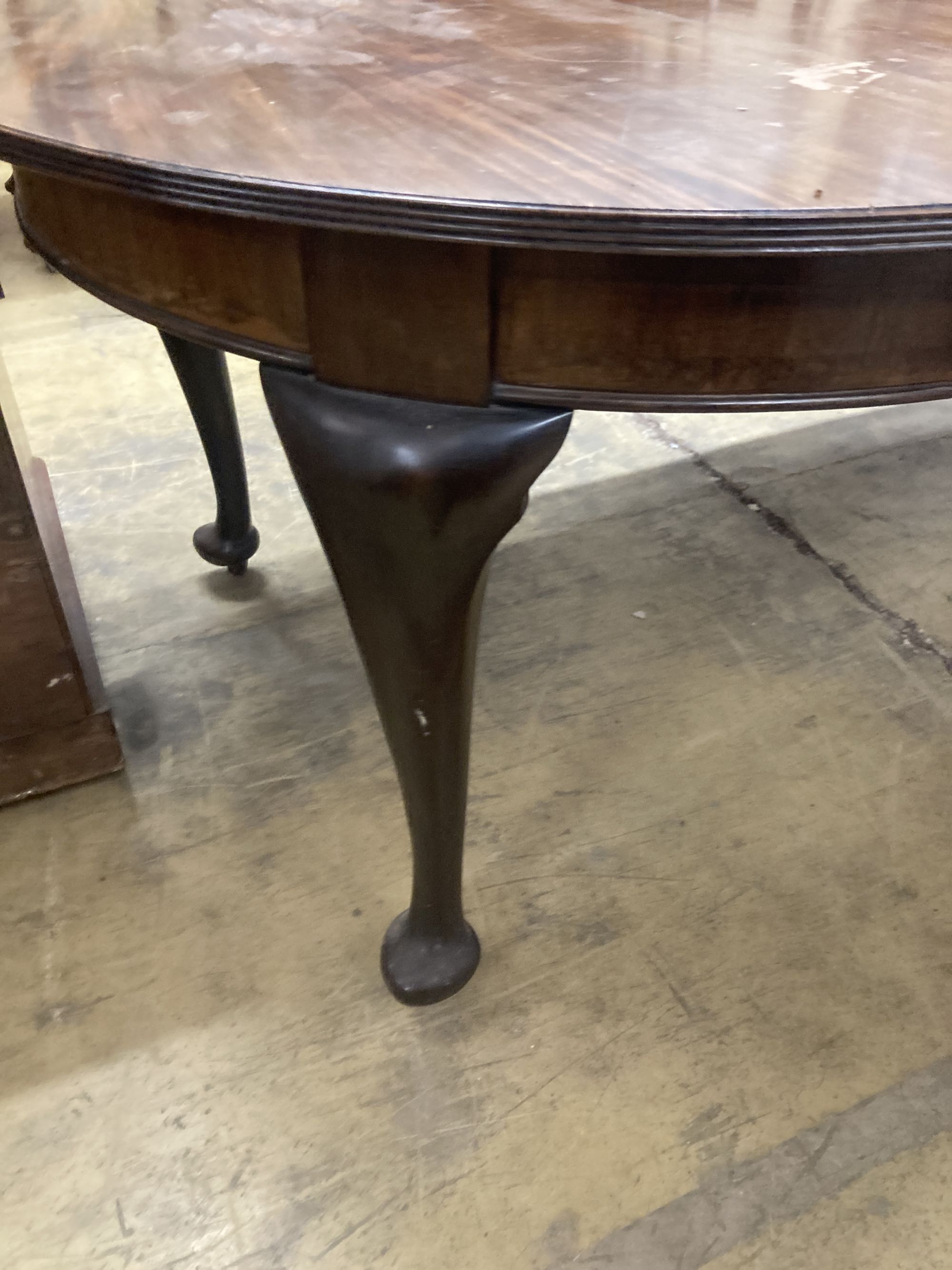 A 1920's circular mahogany extending dining table with three leaves and handle, length approx. 230cm extended, width 120cm, height 75cm